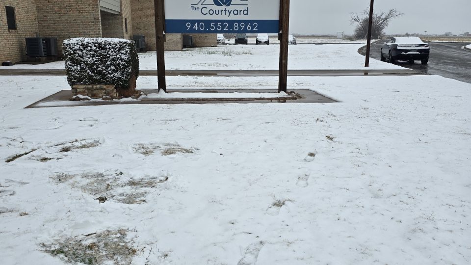 a sign in the snow with a snow covered sign at The  Courtyard