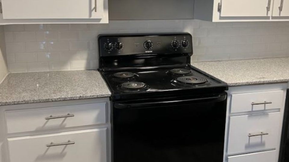 a black stove and oven in a kitchen at The Courtyard